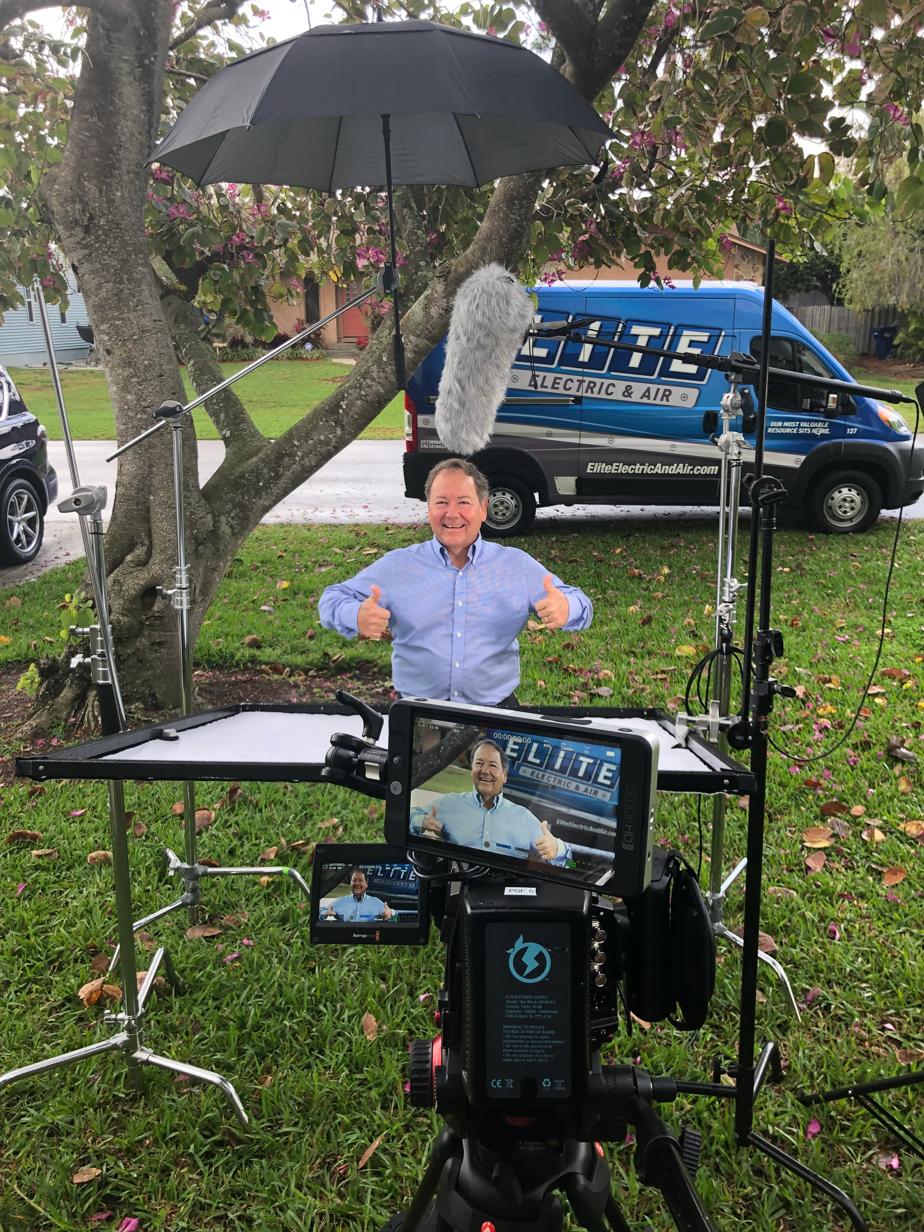 FlyPoint Productions crew filming a brand story interview outdoors, with the subject visible on the camera monitor.