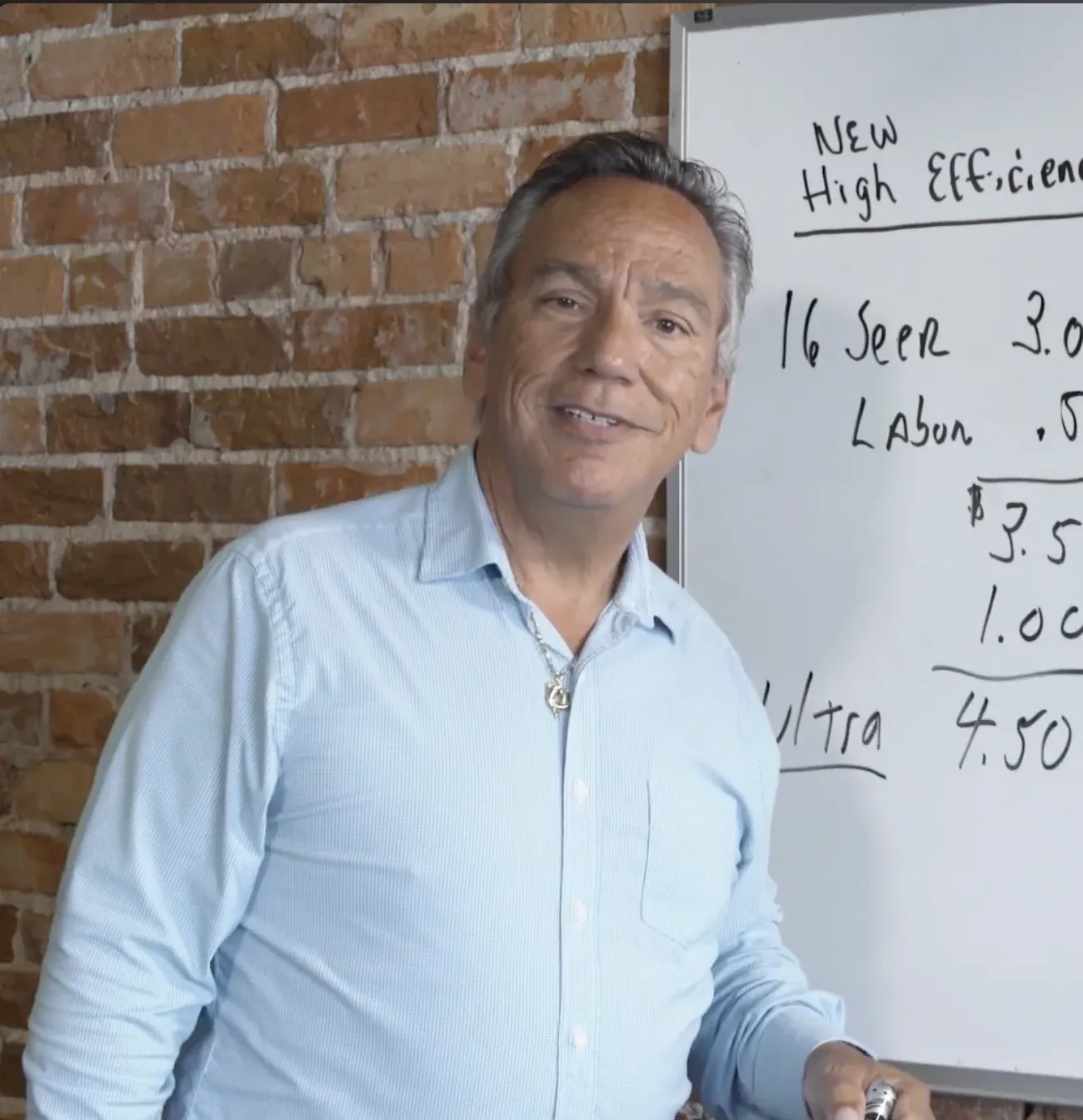 CoolToday training video instructor explaining high-efficiency system costs on a whiteboard.