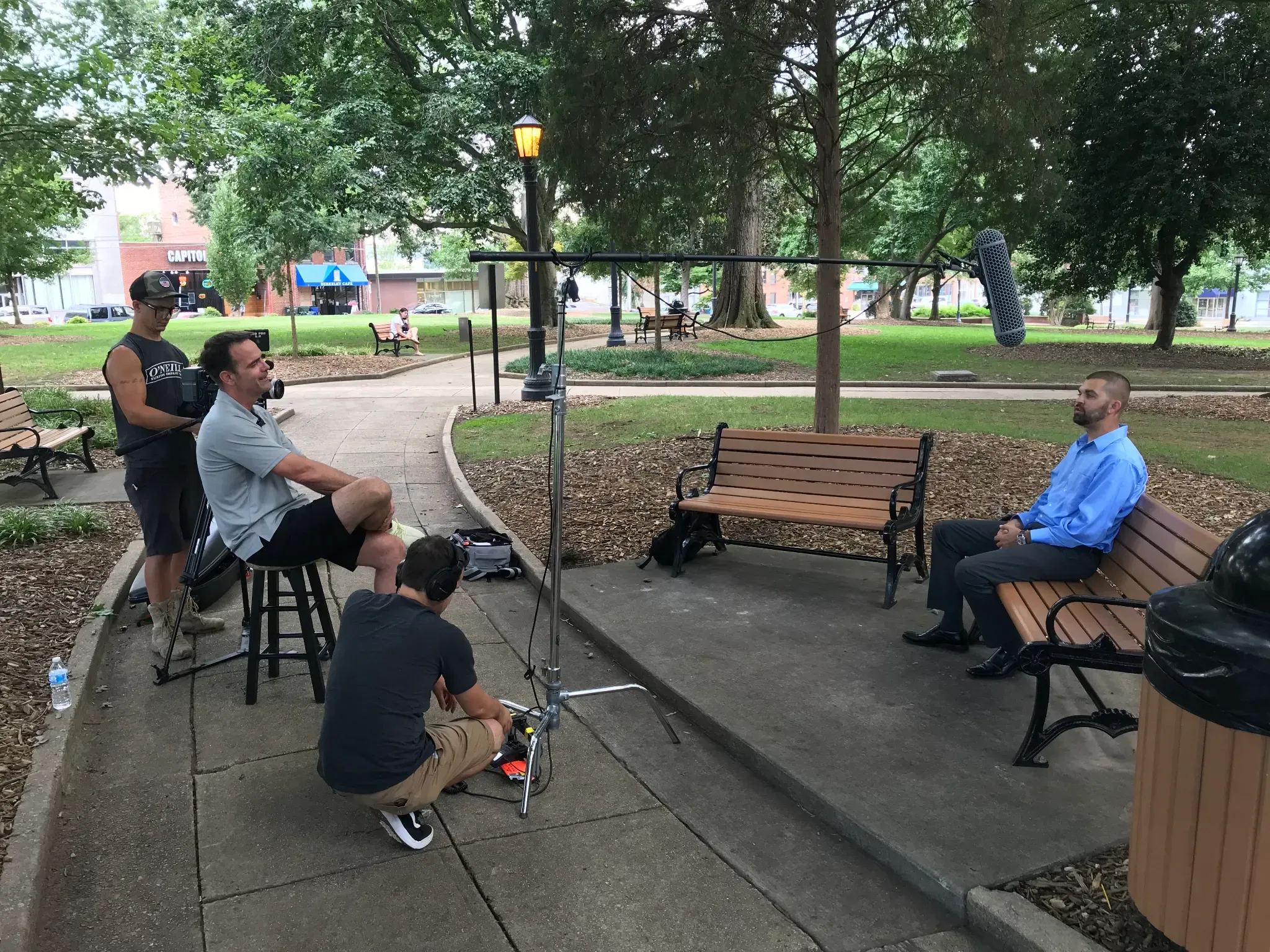 FlyPoint Productions filming a customer testimonial with an interview subject and camera operator outdoors.